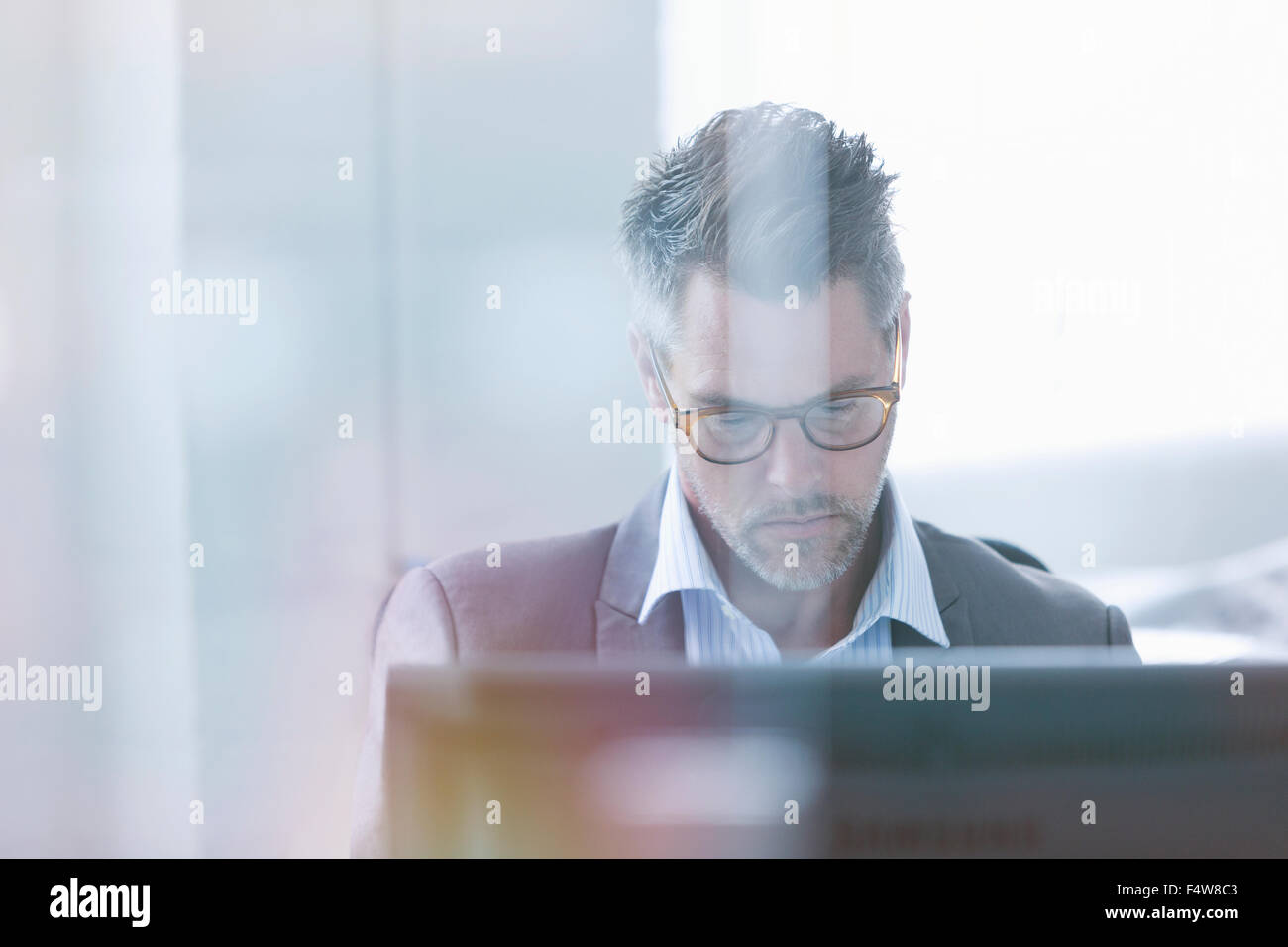 Imprenditore focalizzato l uso dei computer in ufficio Foto Stock