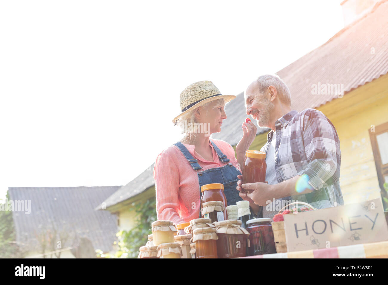 Affettuosa coppia senior vendita di miele al mercato agricolo Foto Stock