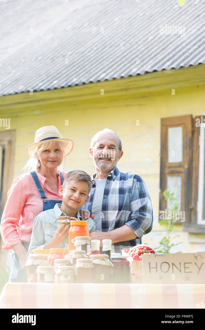 Ritratto ai nonni e nipote di miele di vendita al mercato agricolo in stallo Foto Stock