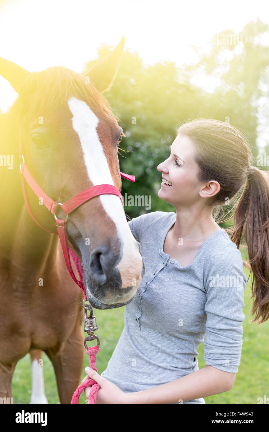 Donna sorridente con cavallo Foto Stock