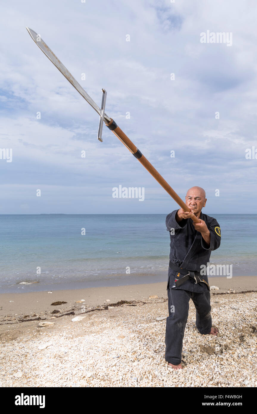 Kensho Tokumura, Hanshi 9th-dan Dento Ryukyu Kobujutsu Hozon Budo Kyokai formazione sulla spiaggia Heshikiya, Katsuren, Okinawa. 德村 賢昌 Foto Stock