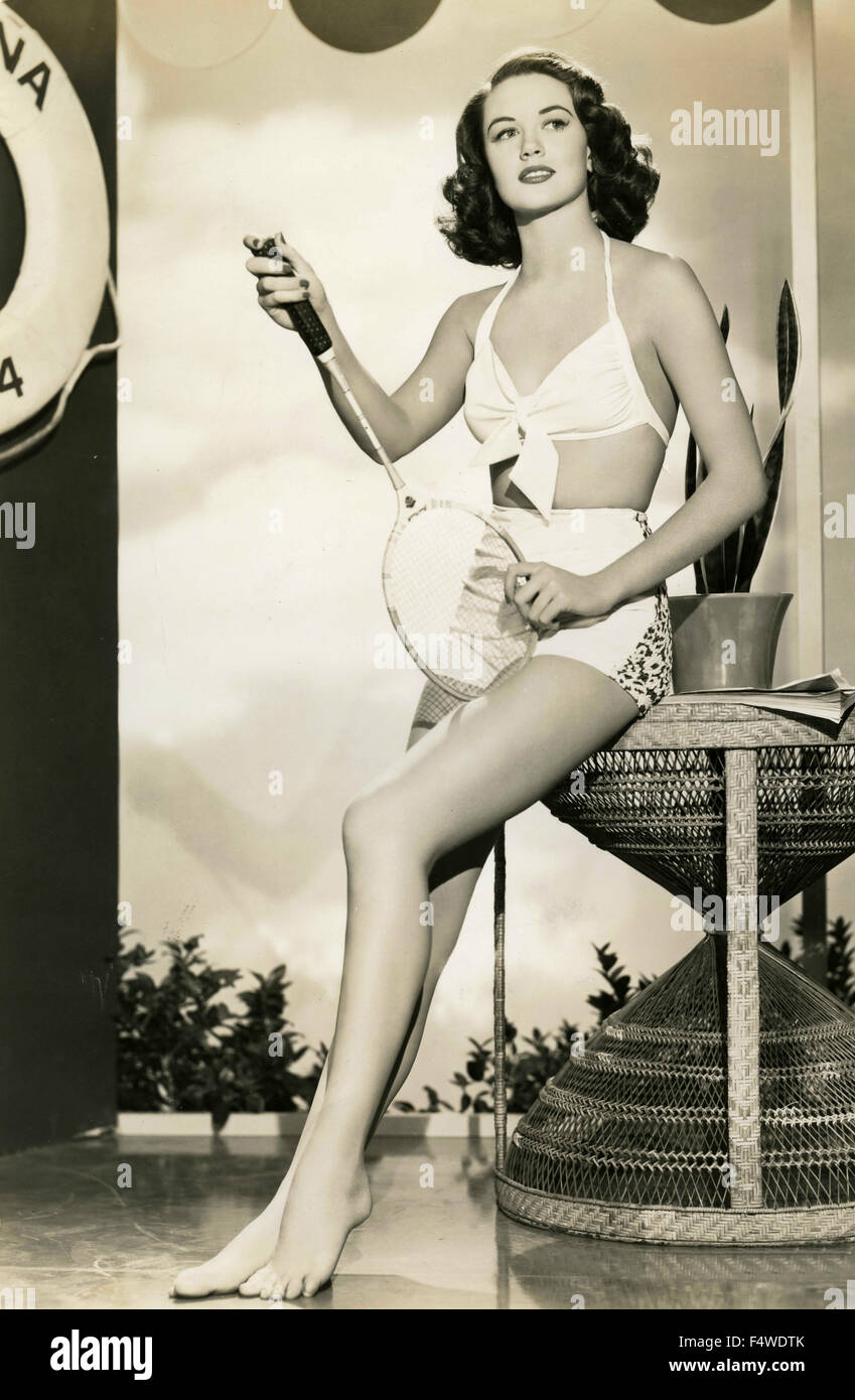 L'attrice americana Dorothy Malone in un costume da bagno ​​white con una racchetta da squash Foto Stock