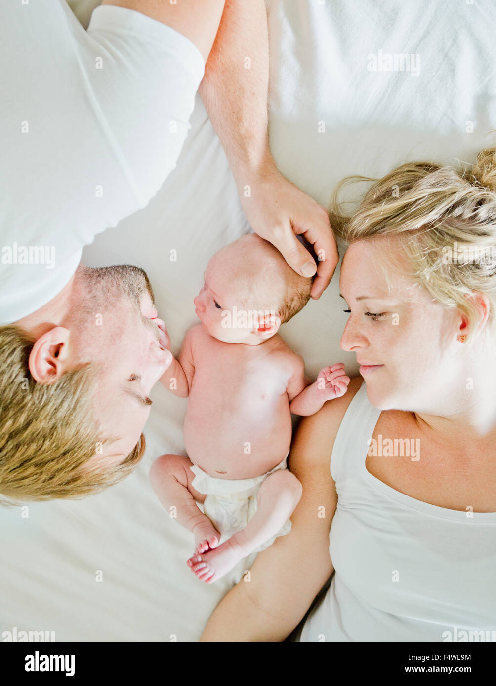 Baby boy (0-1 mesi) con i suoi genitori sul letto Foto Stock