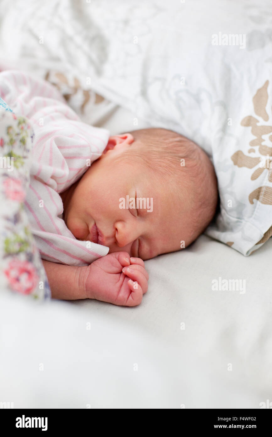 Baby girl (0-1 mesi) dormire nel letto Foto Stock