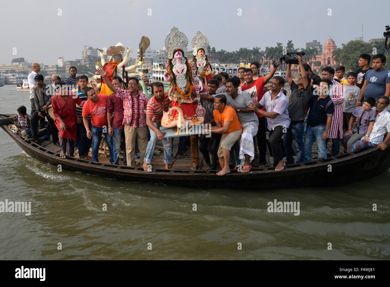 Bengalese devoti indù immergere un idolo della dea Indù Durga nel fiume Buriganga a Dhaka, nel Bangladesh. Il 23 ottobre 2015 la comunità indù terminato le loro quattro giorno lungo festival annuale Durga Puja, il culto della dea Indù Durga, che simboleggia la potenza e la vittoria del bene sul male, con l'immersione degli idoli della dea in Bangladesh. Foto Stock