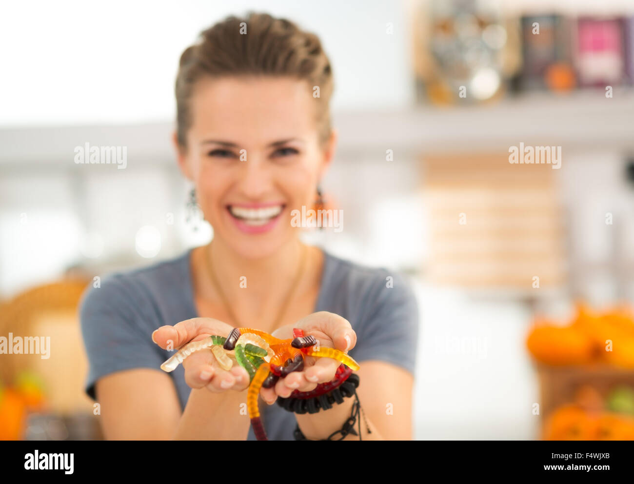 Primo piano sulla colorata halloween worm gommoso caramelle nelle mani della donna. I ragazzi potranno essere stordito! Tradizionale autunno vacanza. Foto Stock