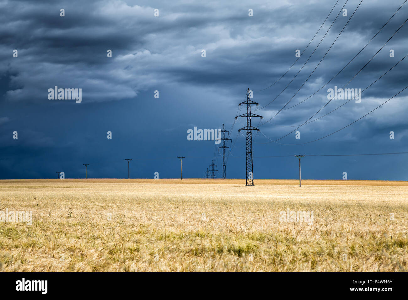 Enorme thundercloud su un campo di grano e pali elettrici a distanza, Repubblica Ceca Foto Stock