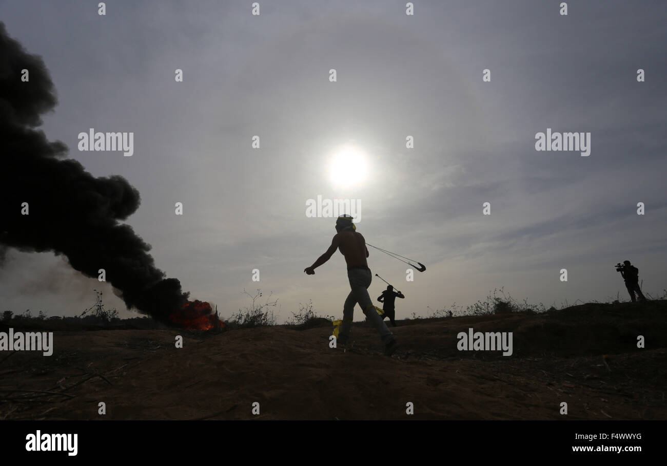 Buriej, Striscia di Gaza, Territori palestinesi. 23 Ott, 2015. Un manifestante palestinese utilizza un sling shot per scagliare pietre durante gli scontri con forze di sicurezza israeliane vicino al confine fra la popolazione israeliana e centro della Striscia di Gaza, il 23 ottobre 2015. Fazioni palestinesi chiamato per manifestazioni di massa contro Israele nei territori occupati della Cisgiordania e di Gerusalemme est in una 'day di rage" Venerdì, come il mondo e i poteri regionali premuto sul con i colloqui per cercare di fine più di tre settimane di spargimento di sangue Credito: Yasser Qudih APA/images/ZUMA filo/Alamy Live News Foto Stock