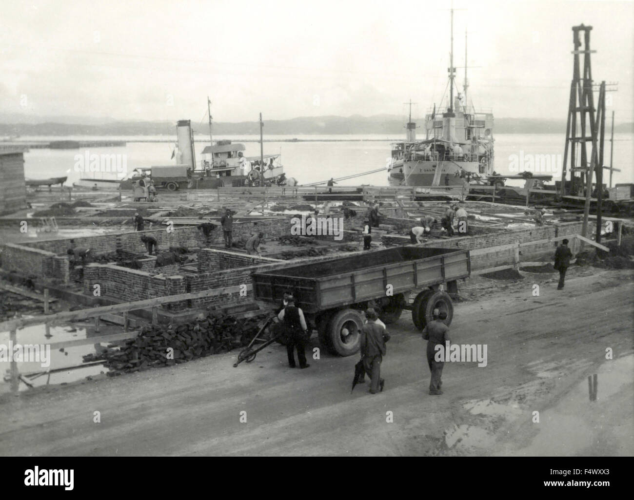 Motoscafo dalmata nella porta accanto alla costruzione di un italiano di base militare in Durazzo, Albania Foto Stock