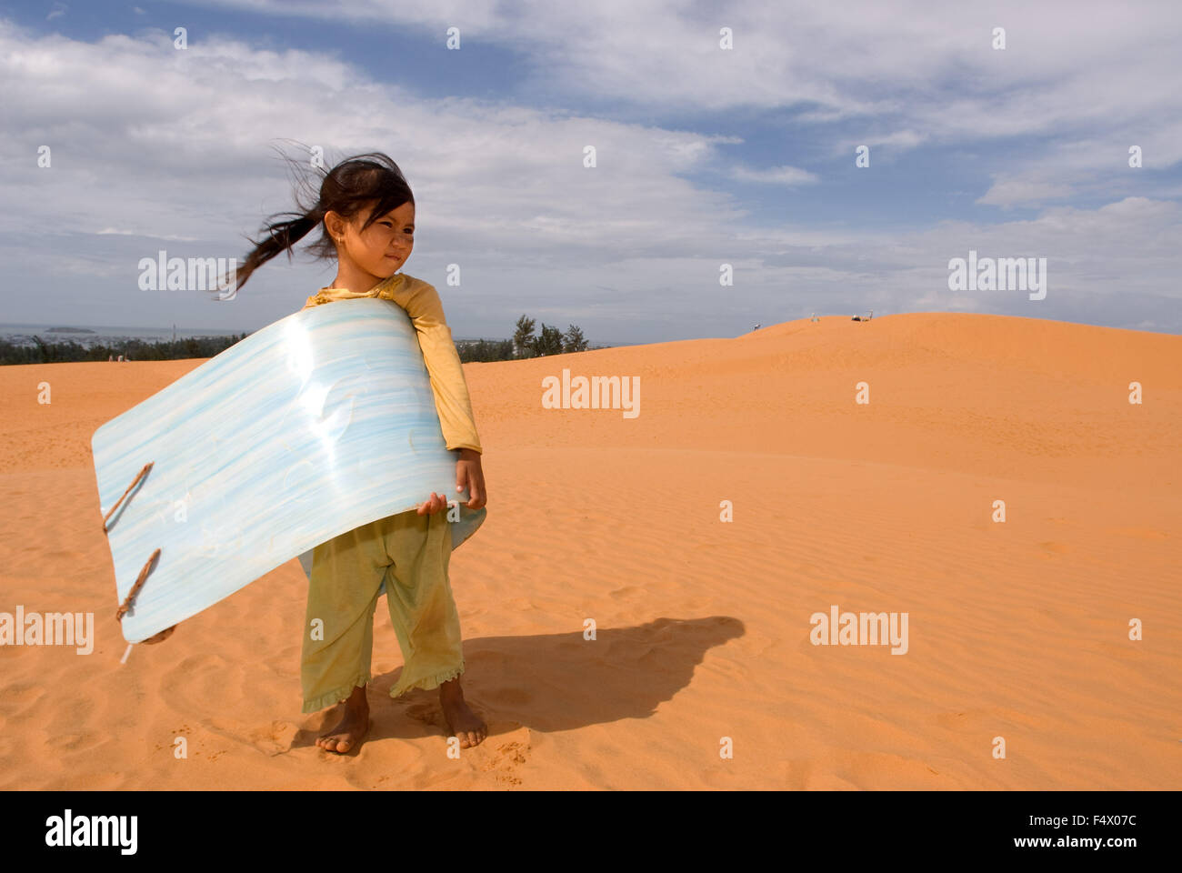 Mui Ne, Vietnam. Ragazza giovane con la slitta di sabbia per il noleggio presso le bianche dune di sabbia. Asia, fuori, dune, scenario, Mui Mui, Ne, natura, Ne, nessuno, rosso, sud-est asiatico, Südvietnam, dune di sabbia, rosso, Vietnam. Foto Stock