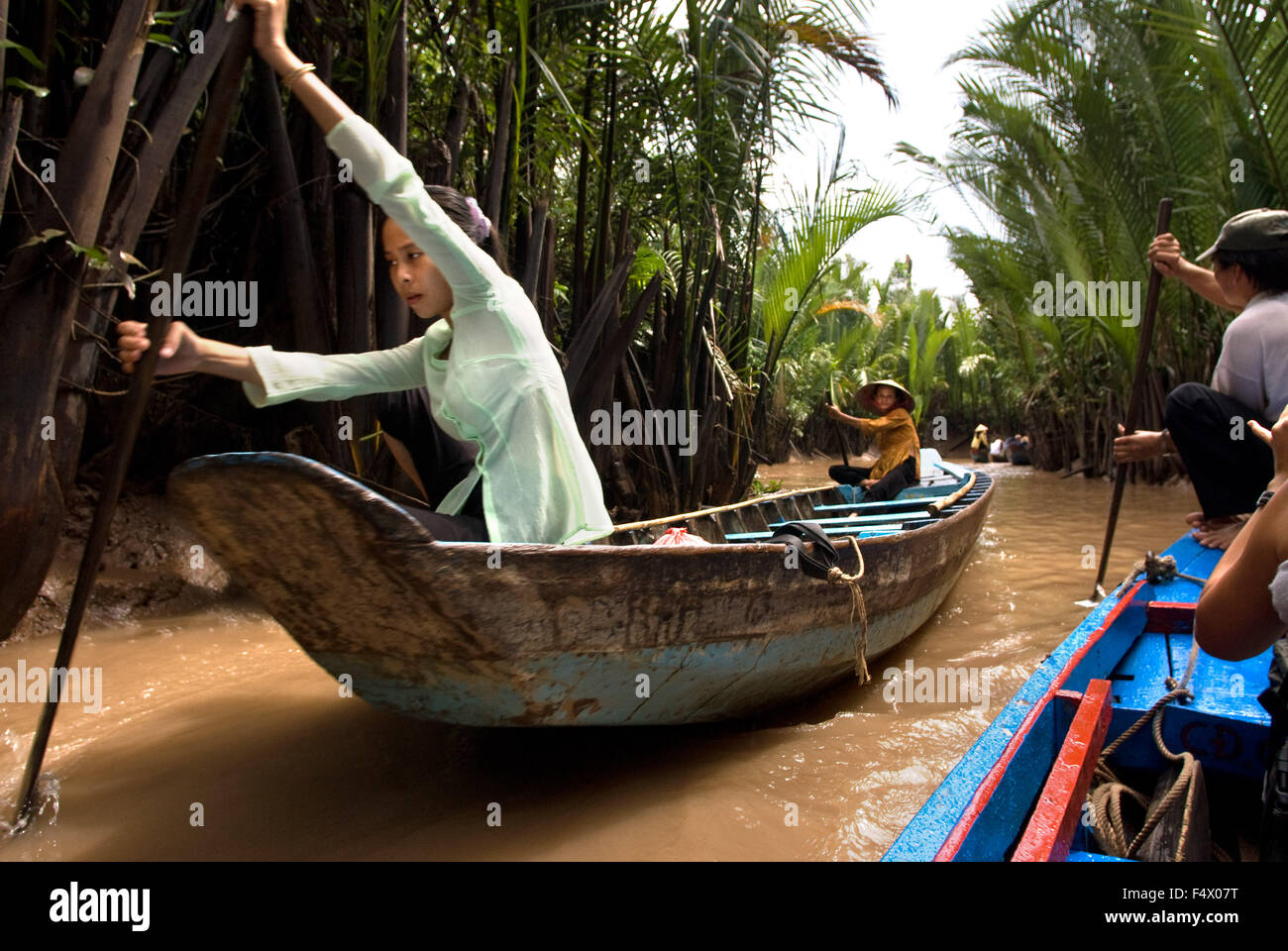 Donna su una barca a remi sul fiume Mekong, vicino a My Tho village, Vietnam. Bao Dinh canale, delta del Mekong. La donna a non conica hat Foto Stock