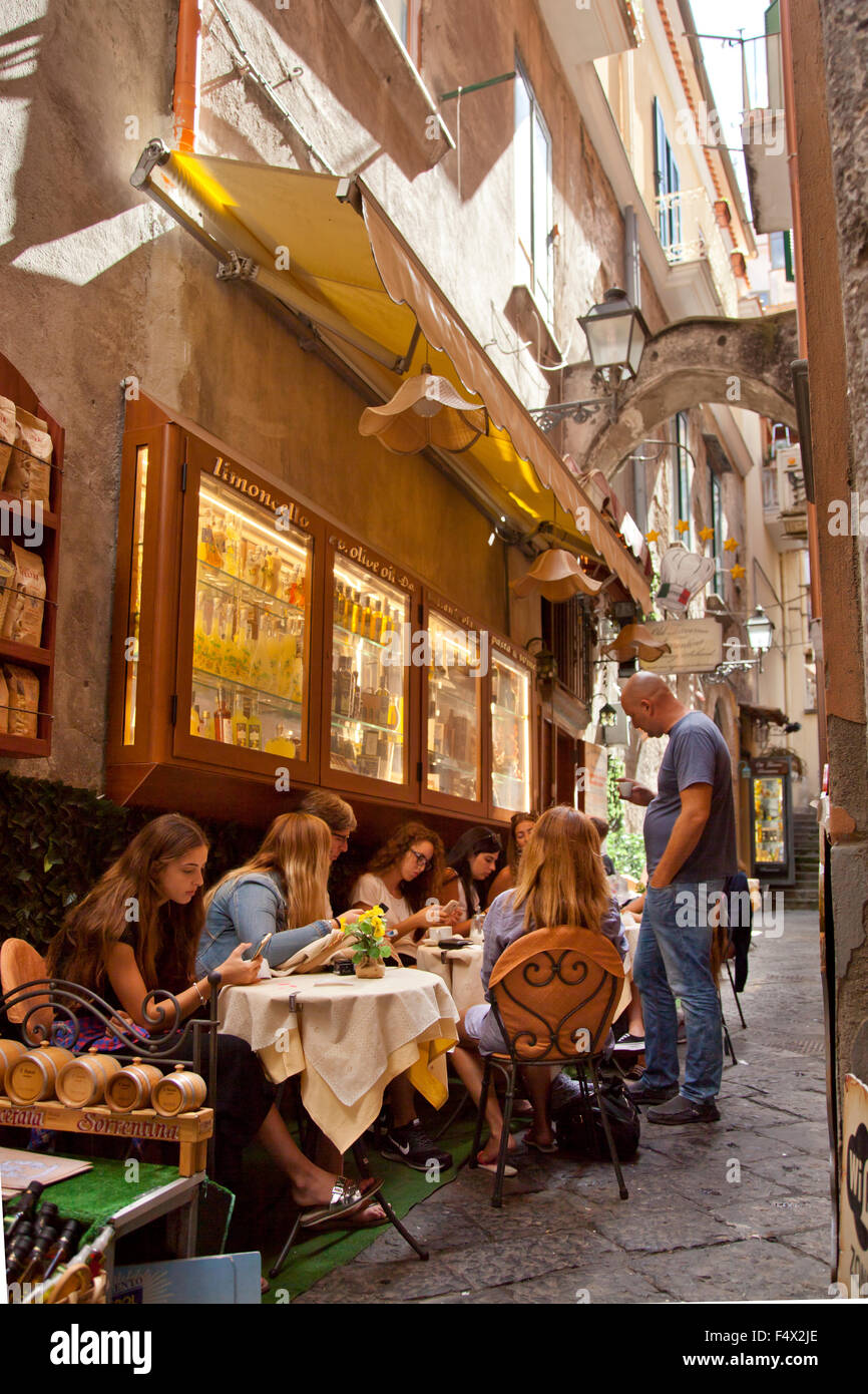 Le persone che usano telefoni cellulari al di fuori al fresco cafe, città vecchia, Sorrento, Italia Foto Stock