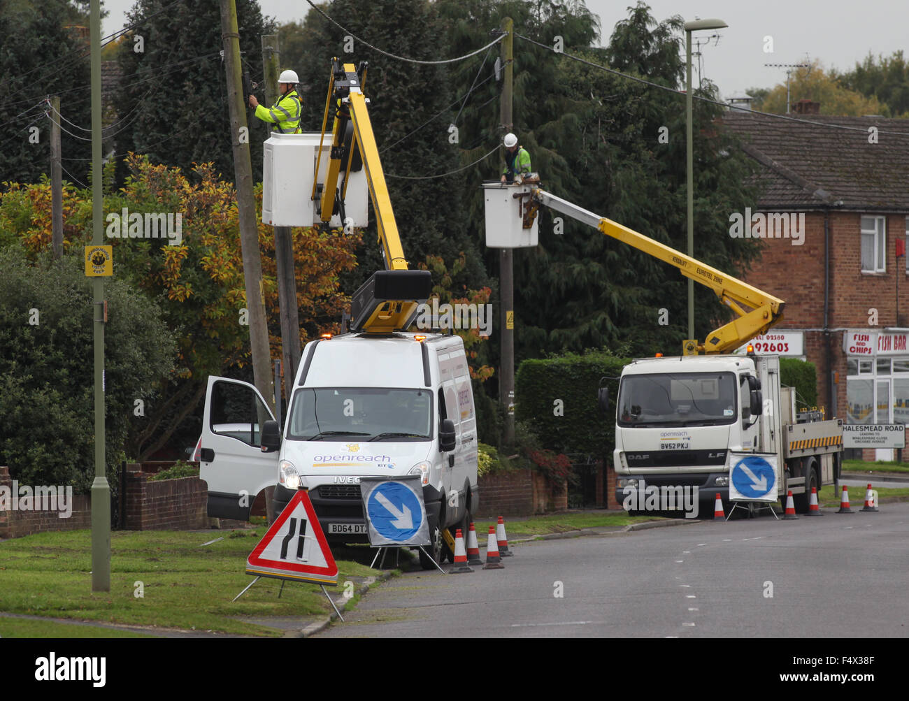 BT Openreach ingegneri aggiornamento linee telefoniche su pali telefonici Foto Stock
