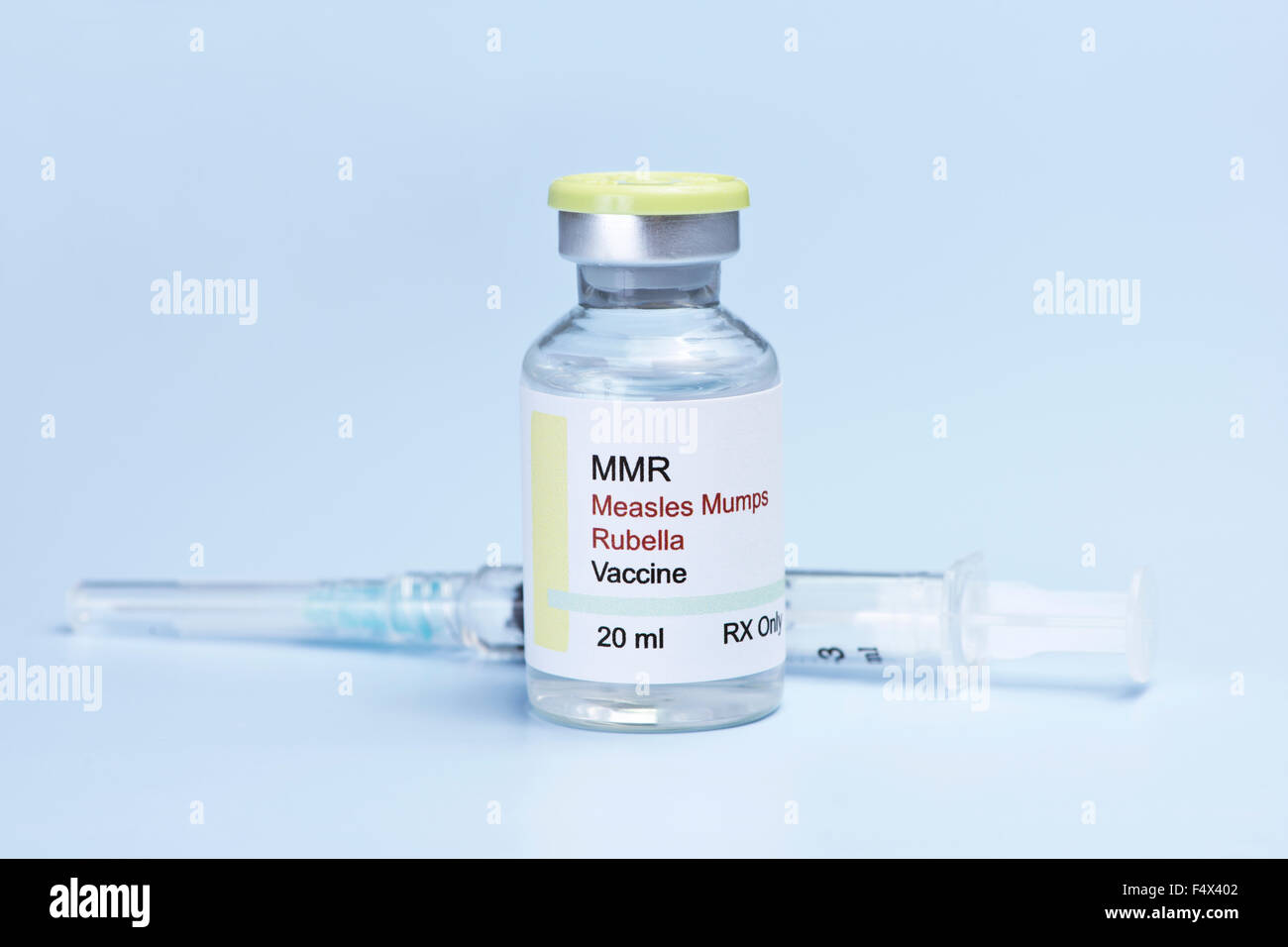 Morbillo, rosolia e parotite, virus vaccino e siringa su sfondo blu. Foto Stock