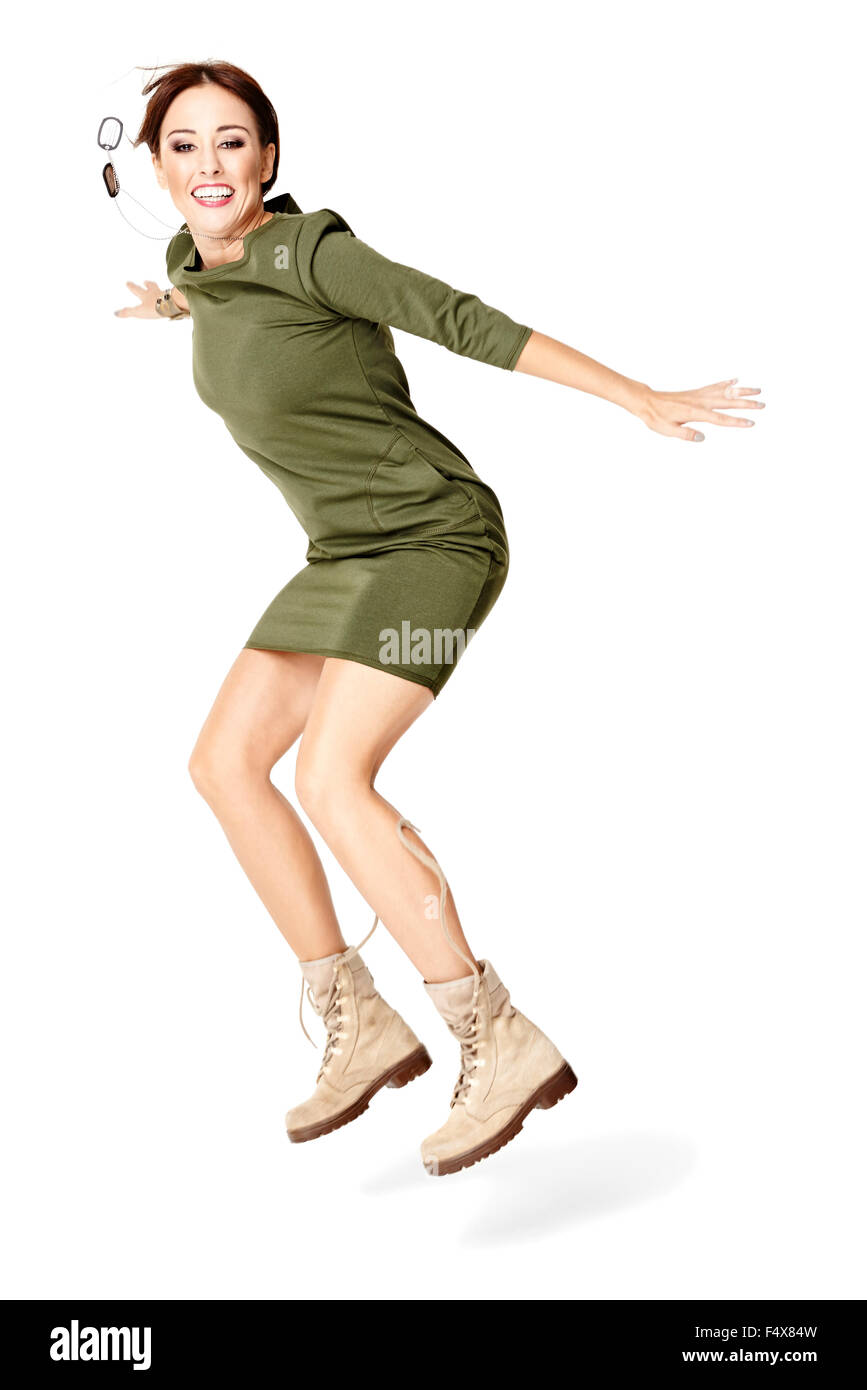 Studio shot di saltare la giovane donna in abito verde. Isolato su bianco. Foto Stock
