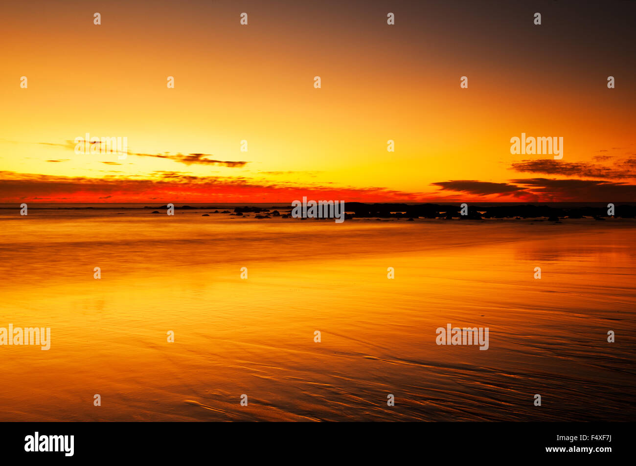 Sunrise riflessioni a Spiaggia di acque profonde. Foto Stock
