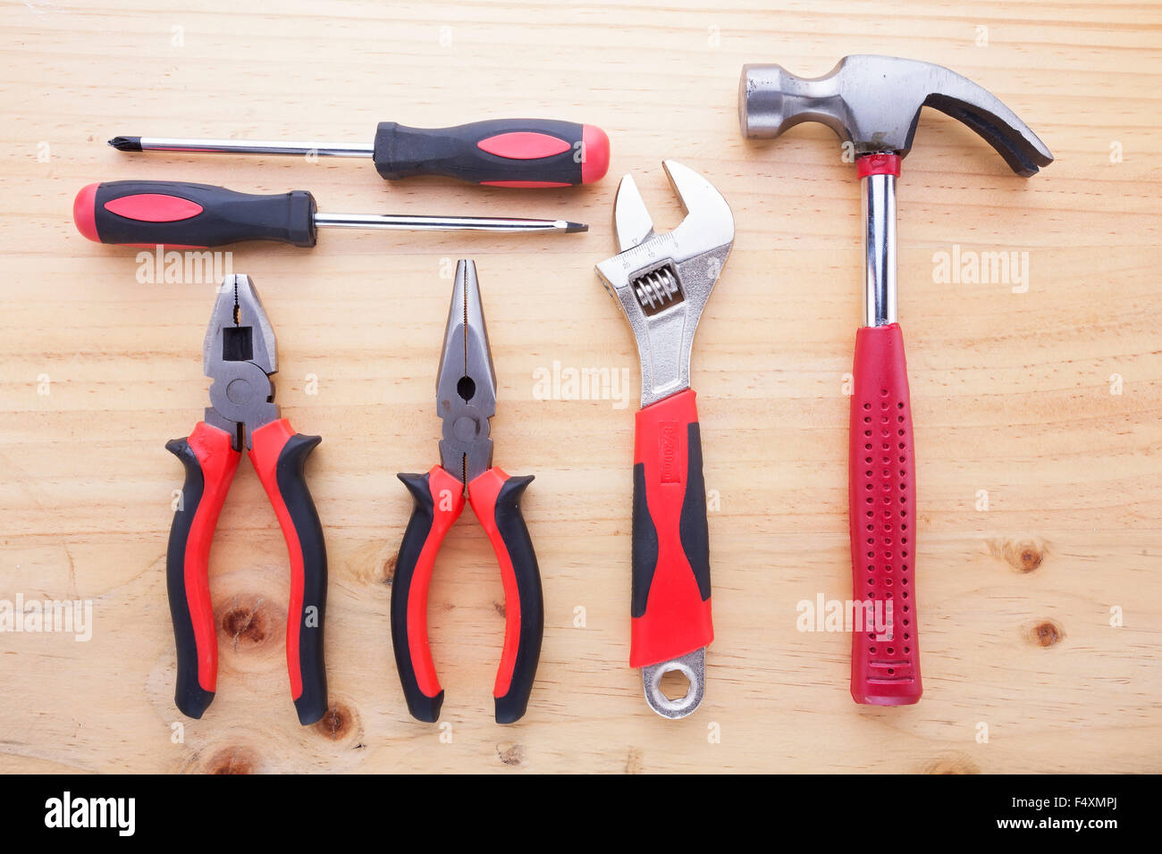 Tipo di differenza di attrezzature su un tavolo di legno (pinze, martelli, chiave e cacciaviti) Foto Stock