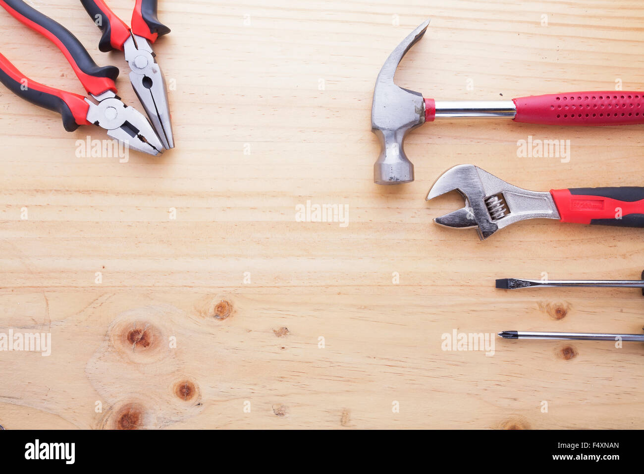 Tipo di differenza di attrezzature su un tavolo di legno (pinze, martelli, chiave e cacciaviti) Foto Stock