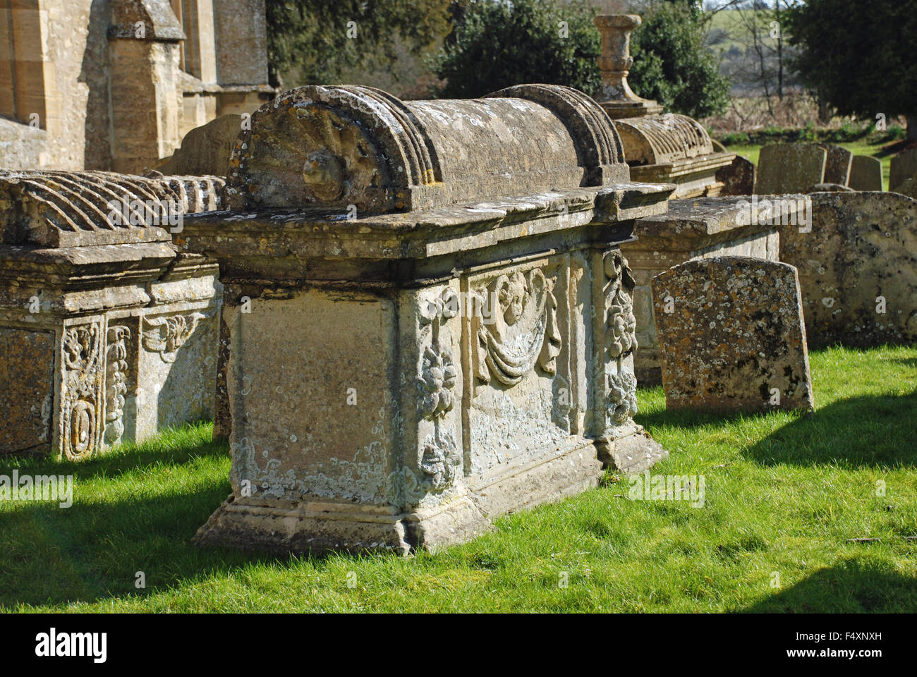 Vecchie lapidi all'esterno della chiesa di San Giovanni Battista nella piccola cittadina di Burford, Oxfordshire. Foto Stock