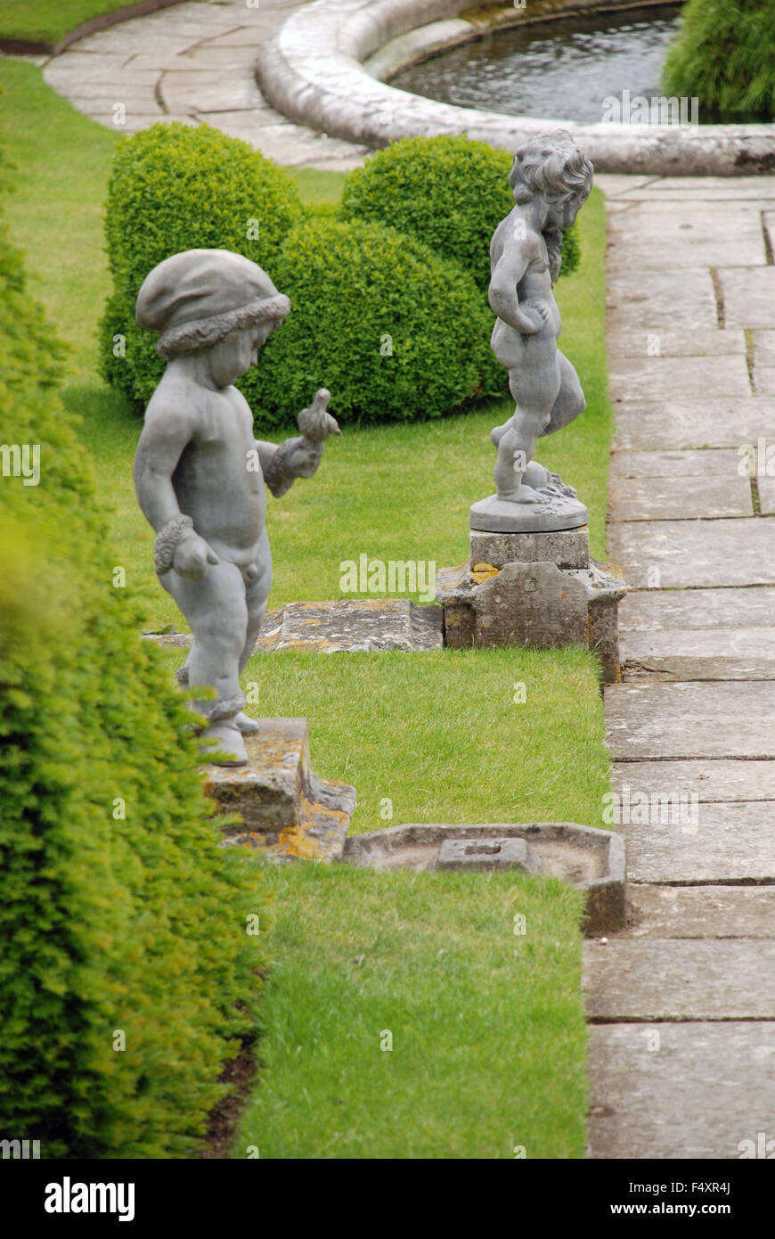 Giardini formali percorso roccioso e ragazzo sculture a Hampton Court Palace a Londra, Inghilterra Foto Stock