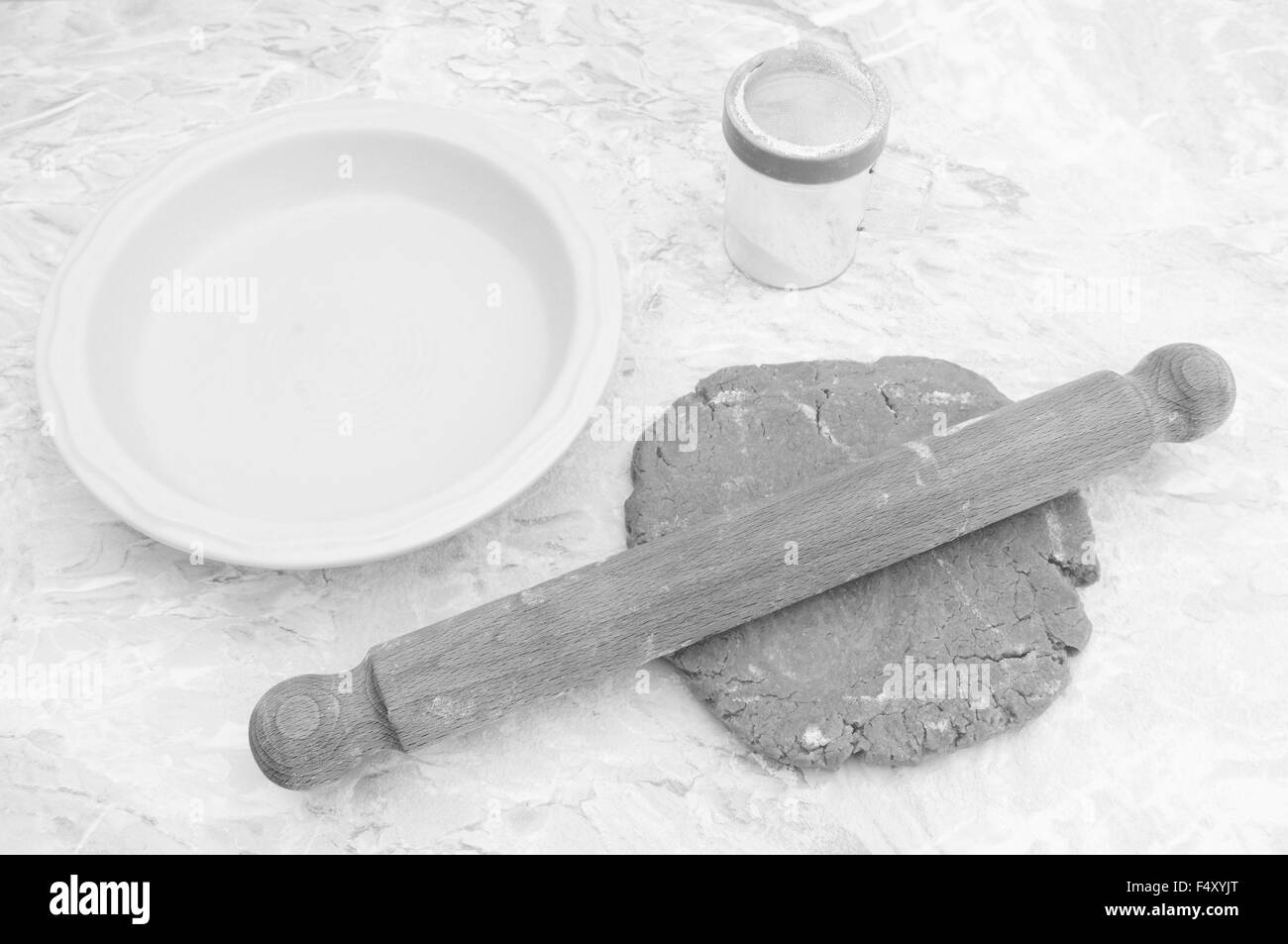Stendere la pasta frolla per una torta, farina drifter e la teglia sul banco di cucina - elaborazione monocromatica Foto Stock
