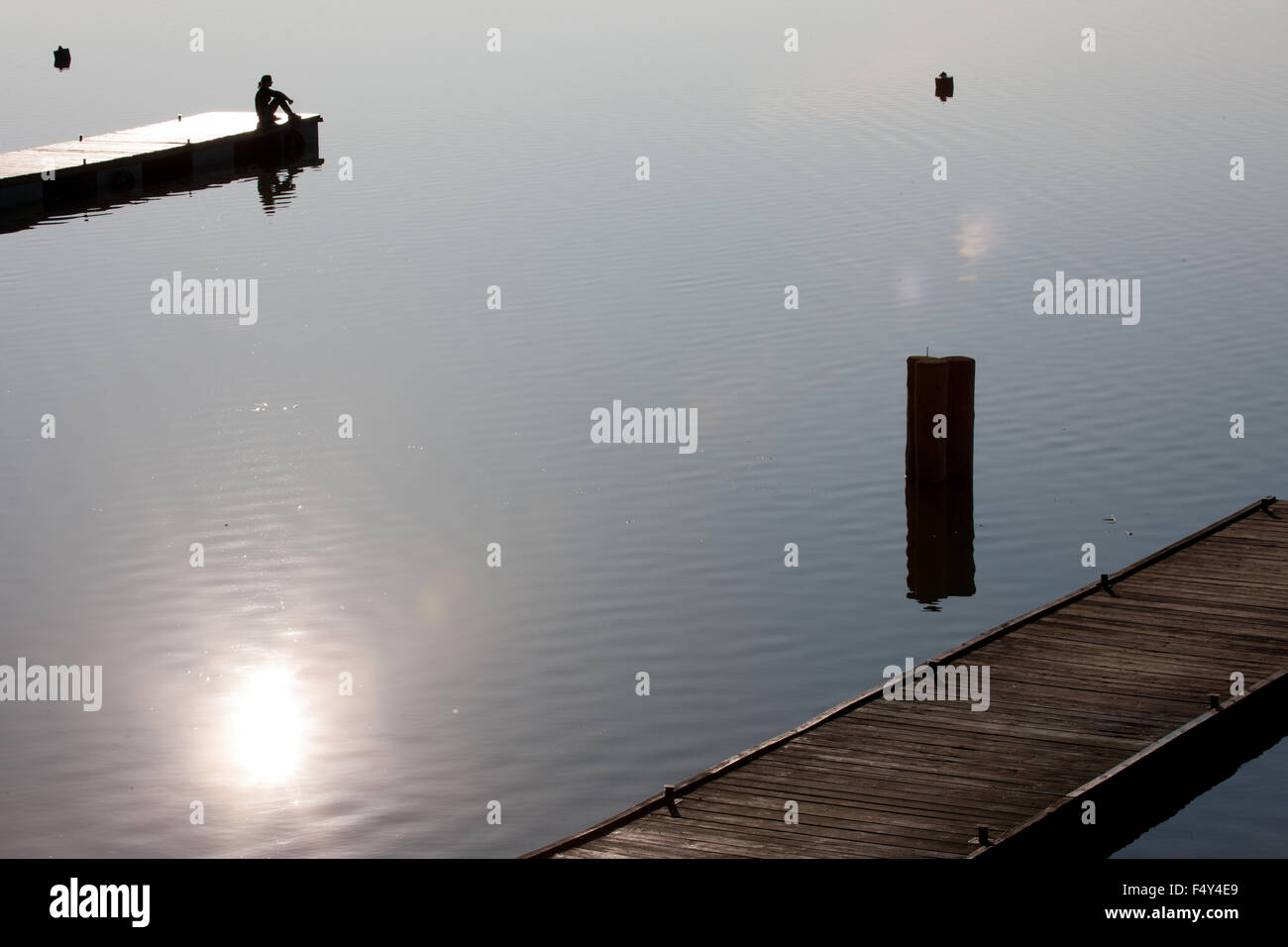 Ragazza seduta sul molo del lago - La Masuria Lakeland, Polonia Foto Stock