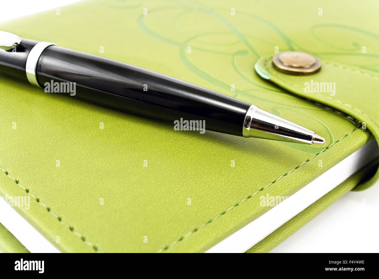 Penna e notebook verde su bianco Foto Stock