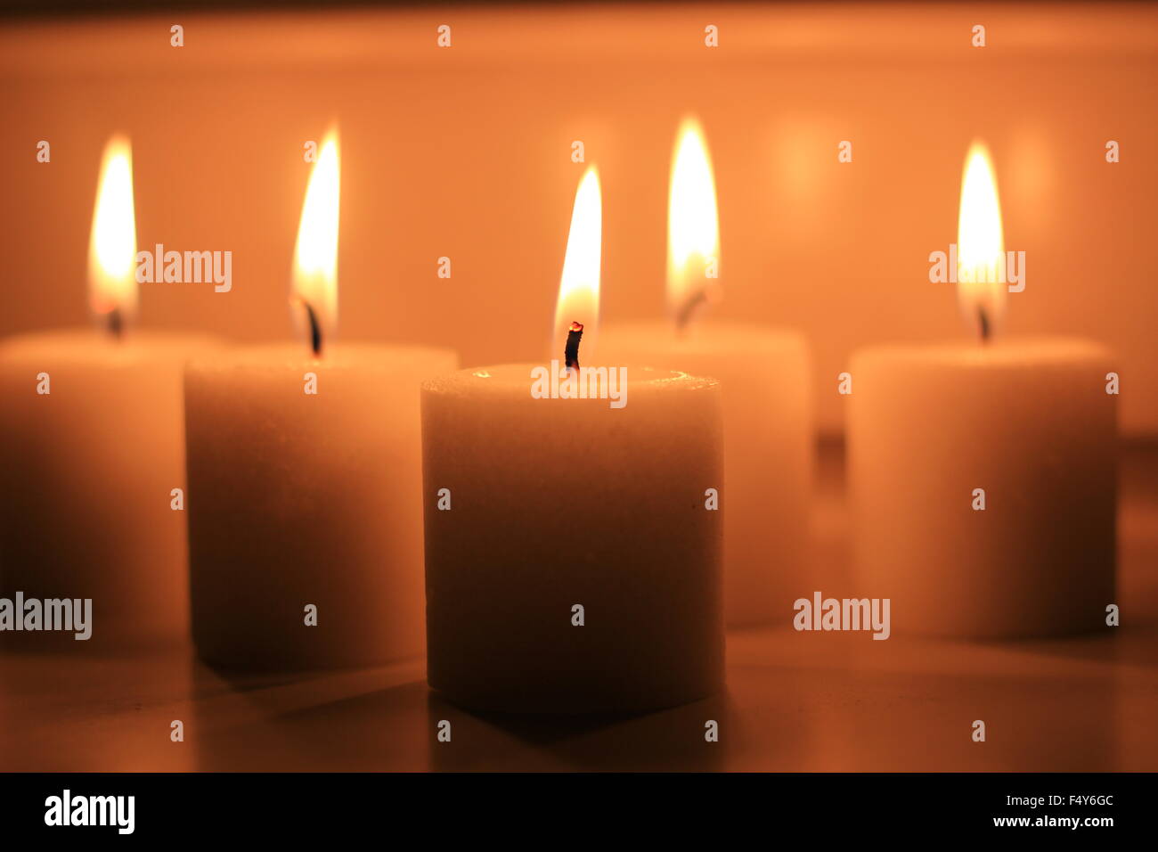 Vacanza candele accese su uno sfondo bianco e riflessa. Foto Stock