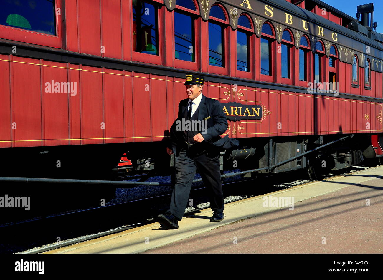 Strasburgo, Pennsylvania: conduttore sulla piattaforma di preparazione a bordo di una annata di legno treno passeggeri a Strasburgo Railroad Foto Stock