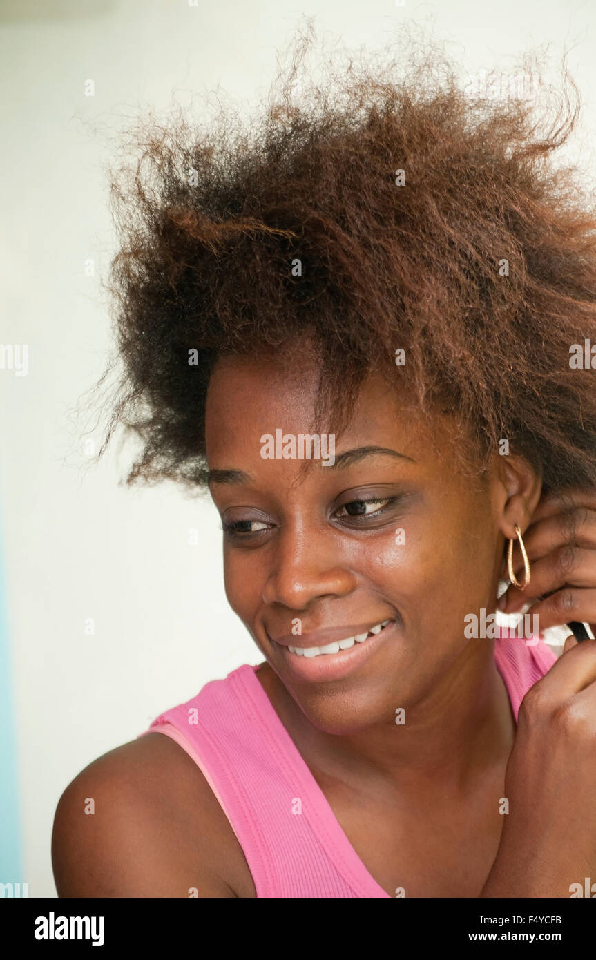 Una giovane donna con capelli crespi sorridente. Foto Stock