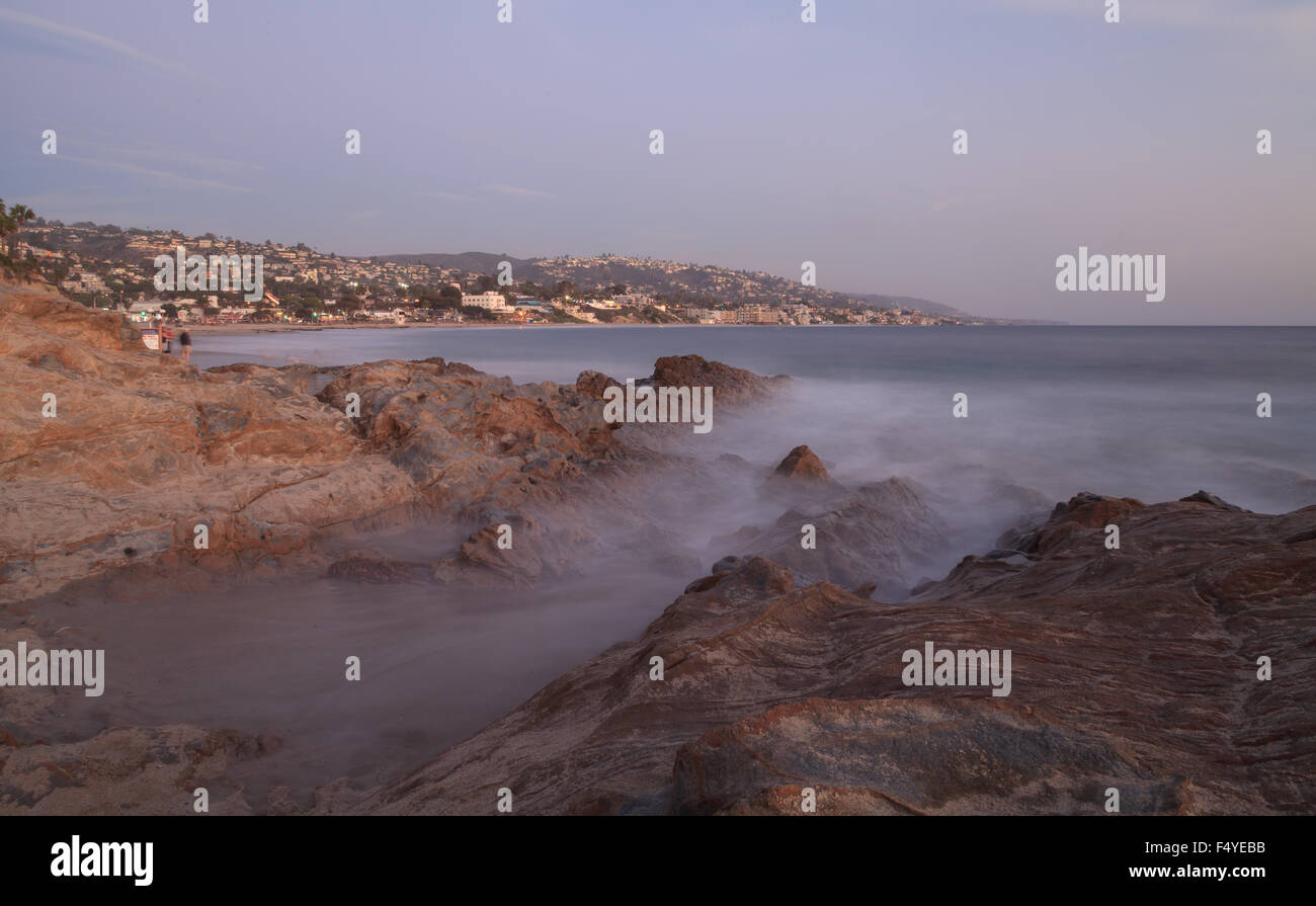 Una lunga esposizione di rocce in onde, dando una nebbia simile effetto sull'oceano in Laguna Beach in California Foto Stock