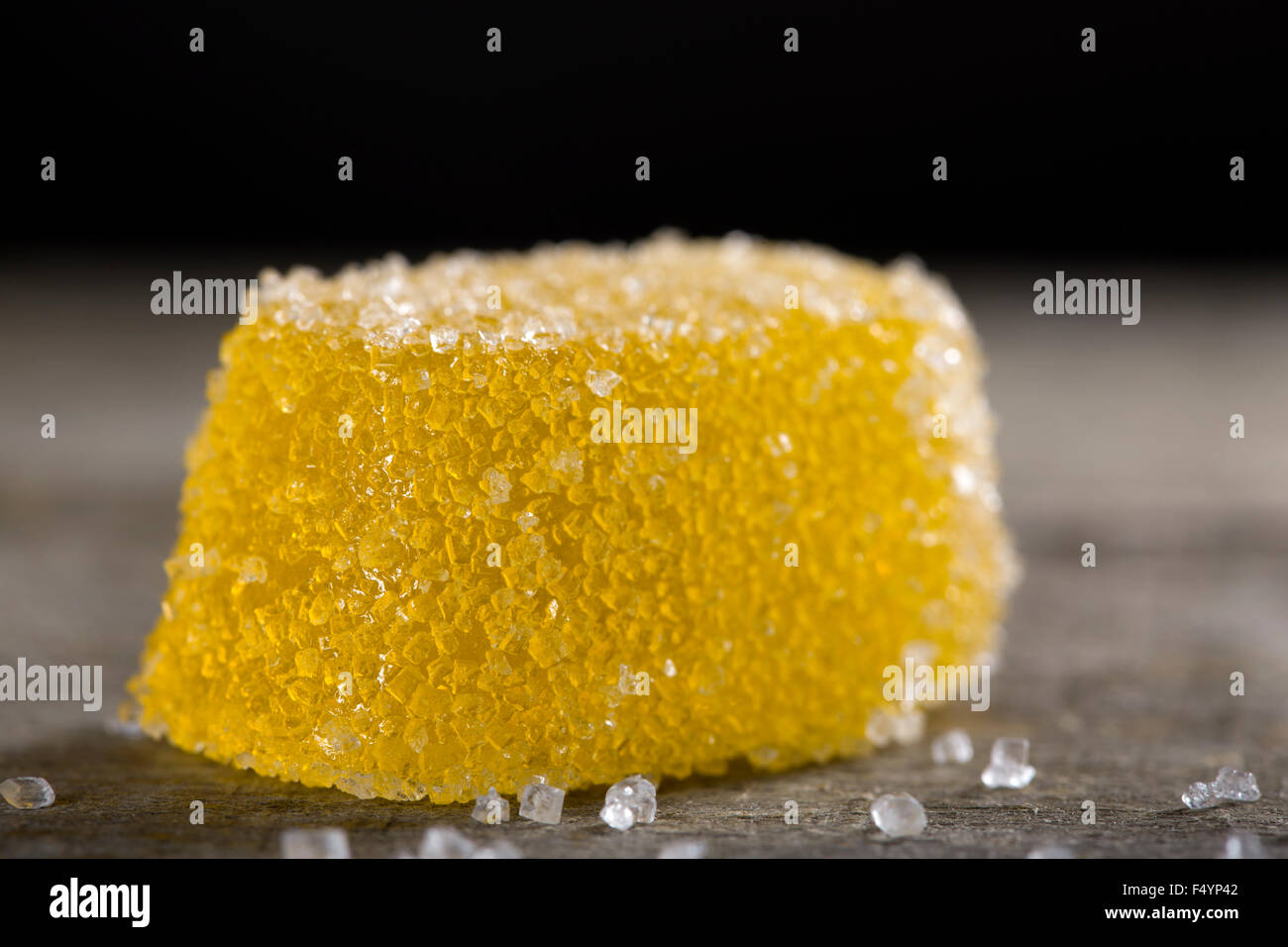 Uno giallo jelly caramelle con zucchero bianco su sfondo di legno Foto Stock
