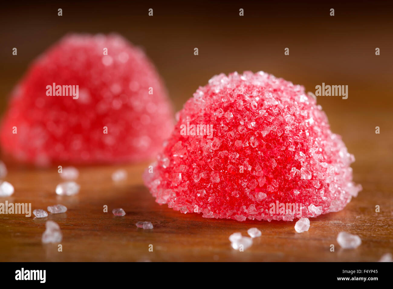 Due red jelly caramelle con zucchero bianco su sfondo di legno Foto Stock