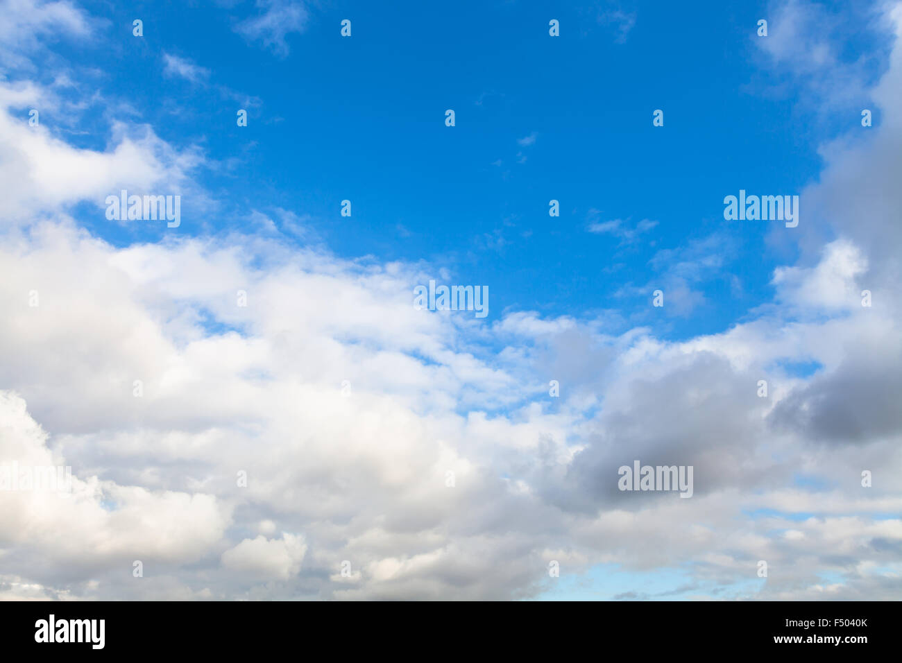Sfondo naturale - bassa grigio e bianco autunno nuvole nel cielo blu Foto Stock