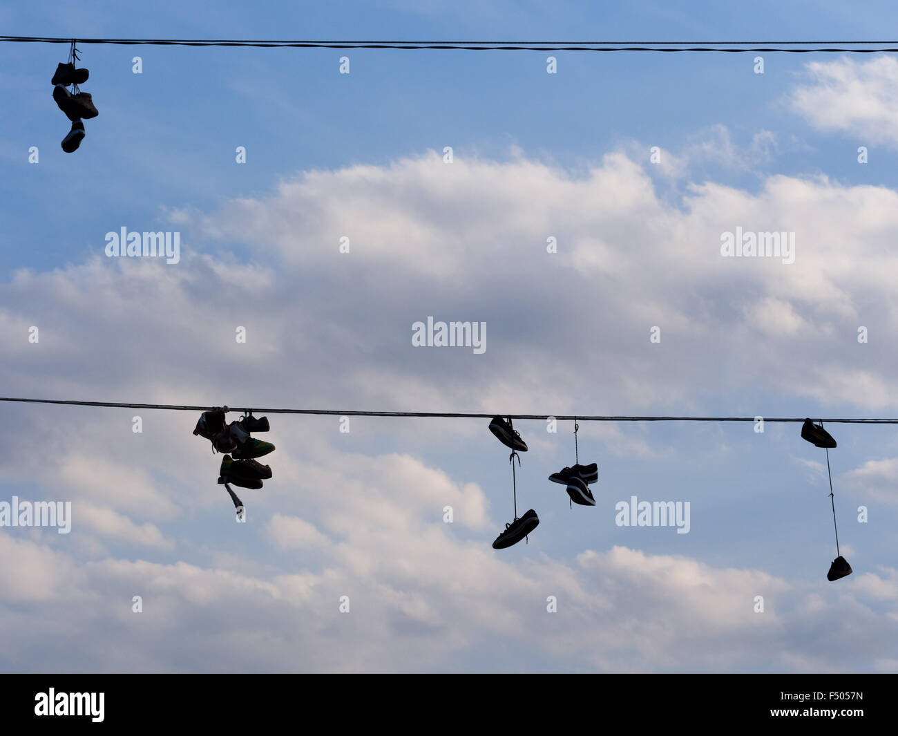 Scarpe appesi da linee di alimentazione dai loro laces Foto Stock