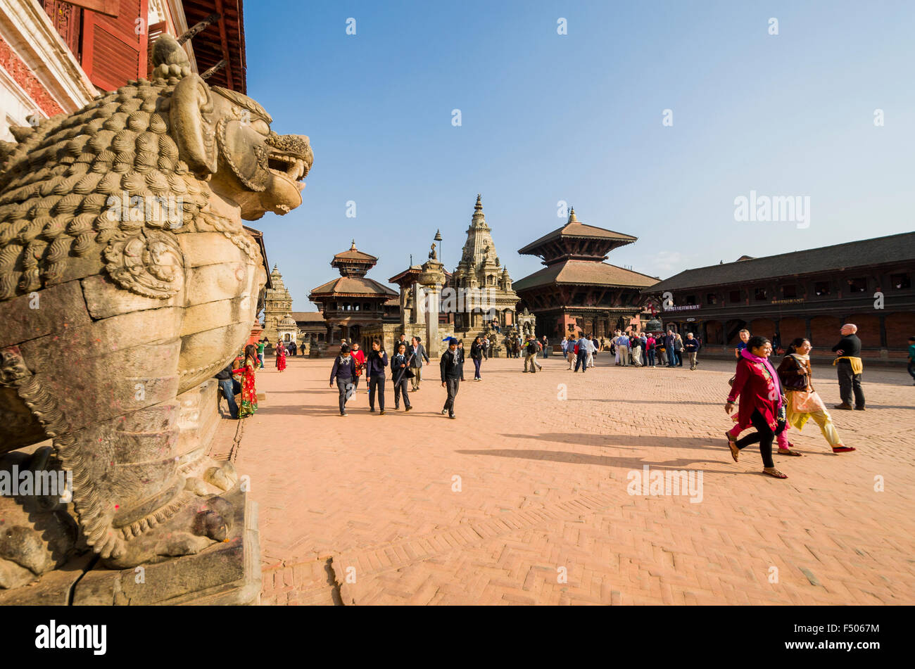 La gente che camminava sul Durbar Square, la porta del leone in primo piano Foto Stock