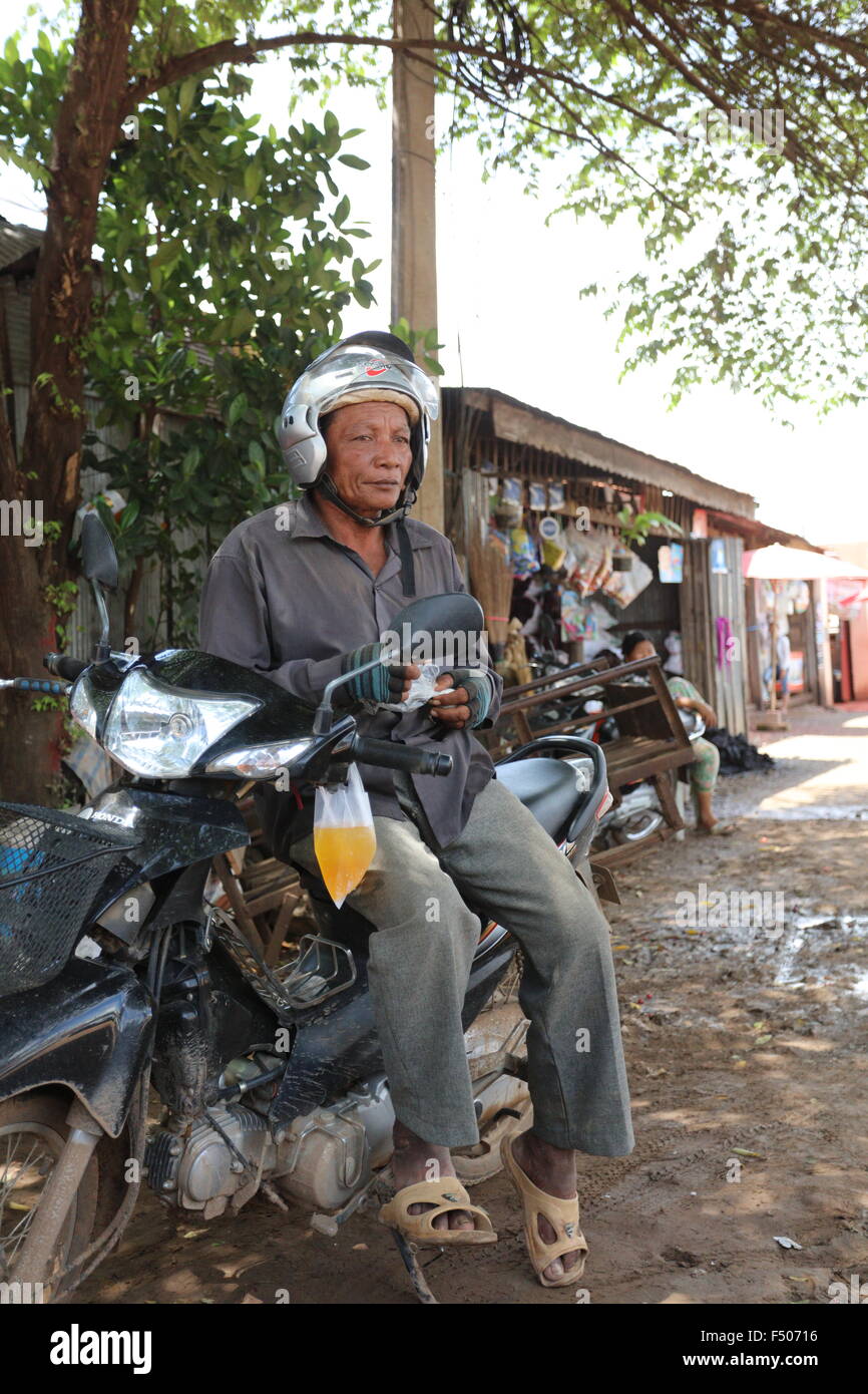 Uomo seduto su uno scooter e indossa un casco Foto stock - Alamy