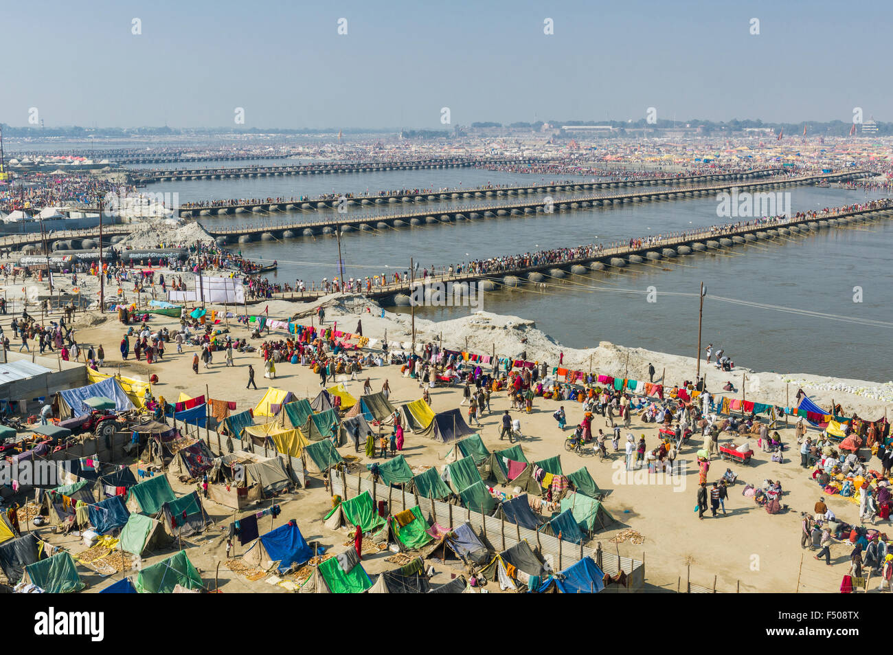 Molti attraversa per mezzo di pontoni ponti che attraversano il fiume Gange sul kumbha mela di terra Foto Stock