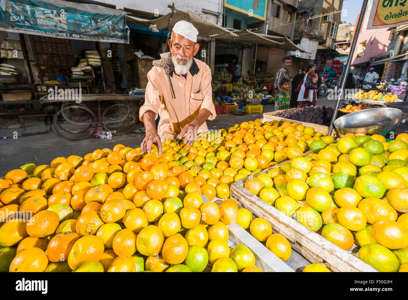 Un venditore sta offrendo le arance in un carrello di spinta al mercato ortofrutticolo Foto Stock