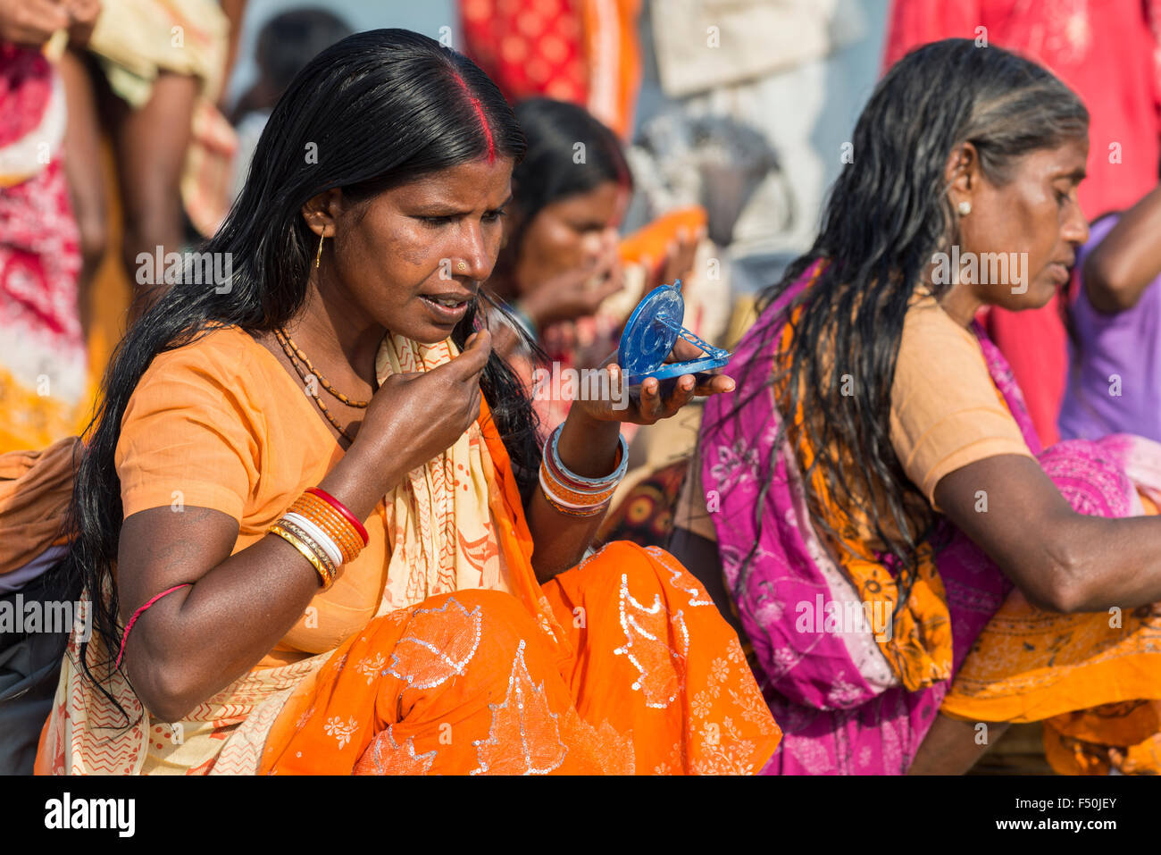 Un gruppo di pellegrini femminile, le donne stanno applicando tilaks dopo tenendo bagno e pregando nel santo fiume Yamuna Foto Stock