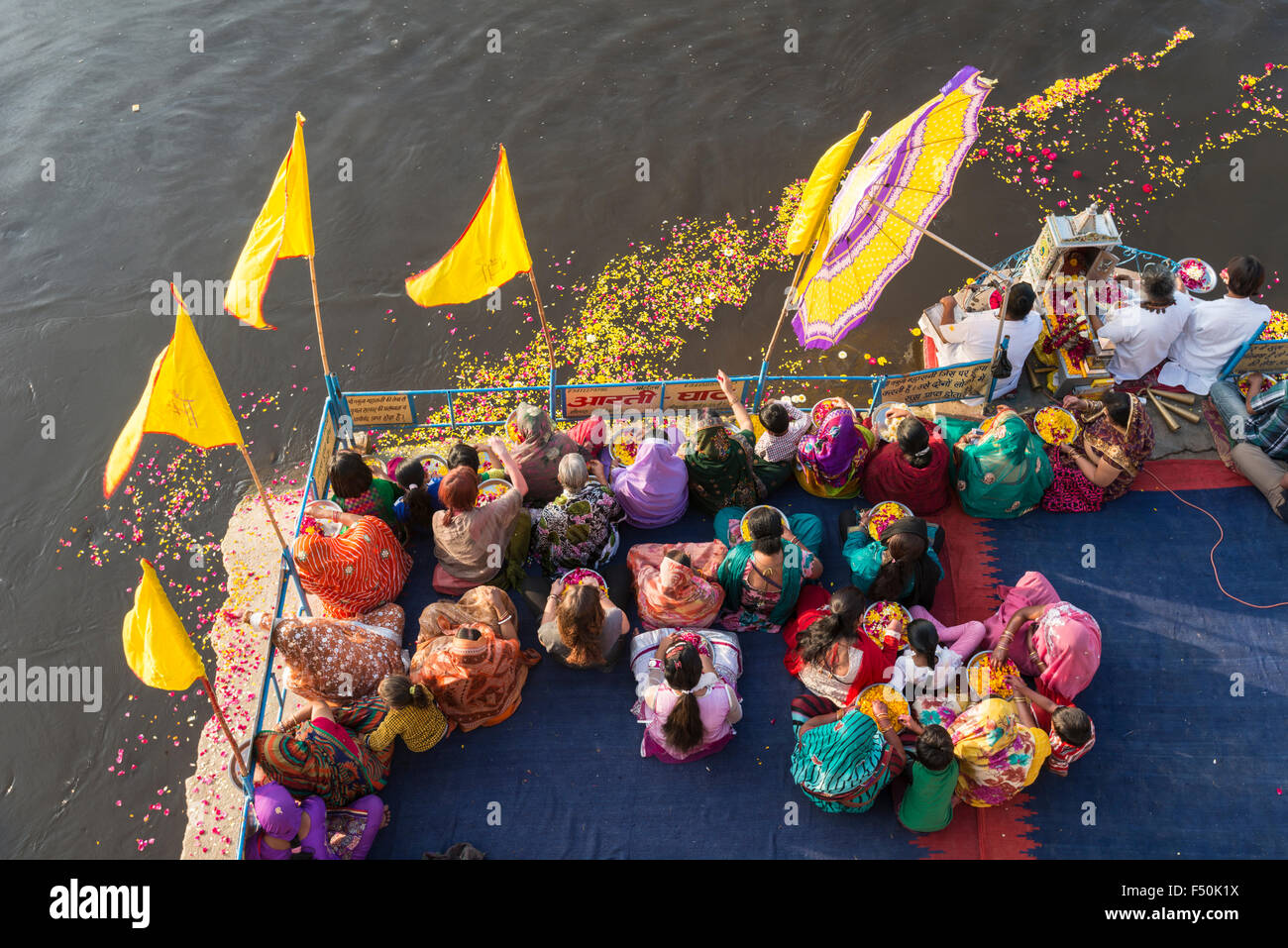 Alcuni pellegrini femminile, le donne, si celebra un rito, pooja, sul ghats presso il santo fiume Yamuna, visto da sopra Foto Stock
