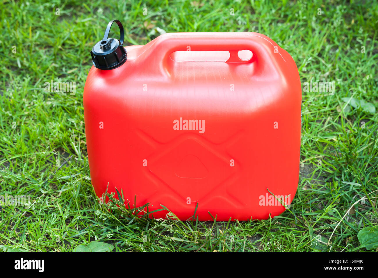 Red Bidone in plastica sorge su un verde prato estivo Foto Stock
