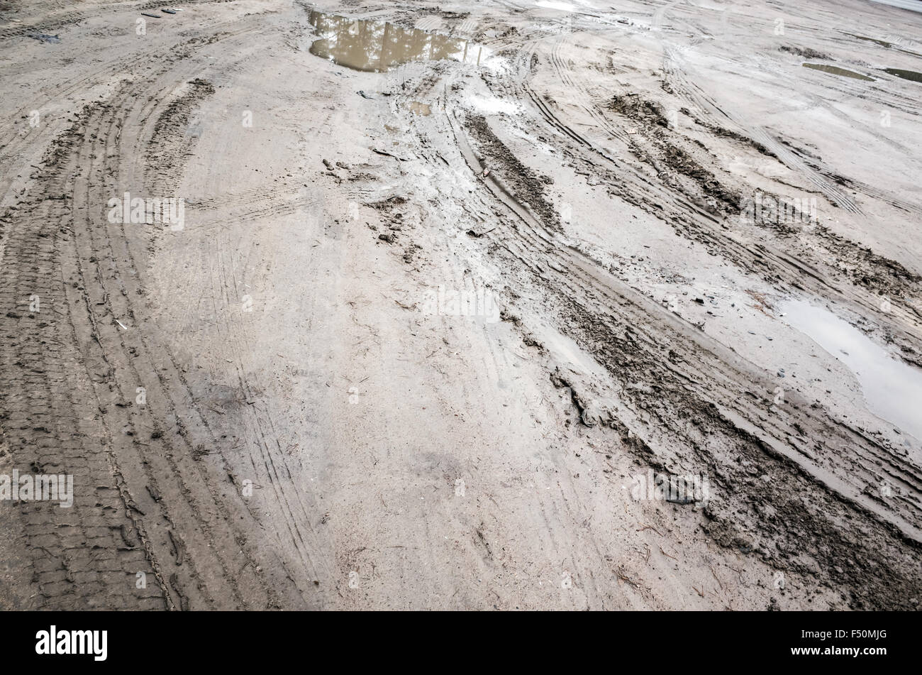 Tracce di pneumatici su fango rurale strada sporca con pozzanghere Foto Stock