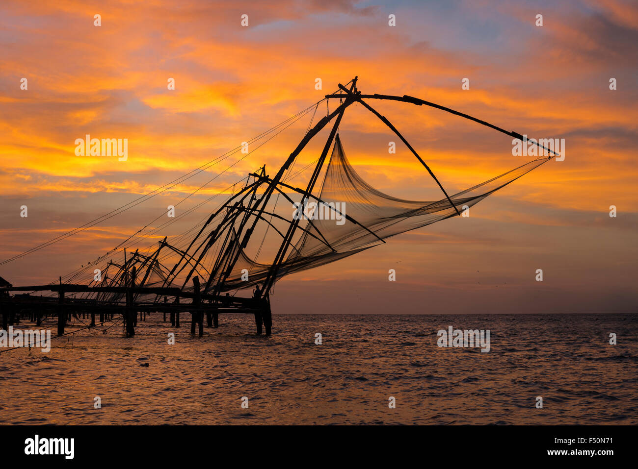 Cinese di reti da pesca, situato in fort kochi, al tramonto Foto Stock