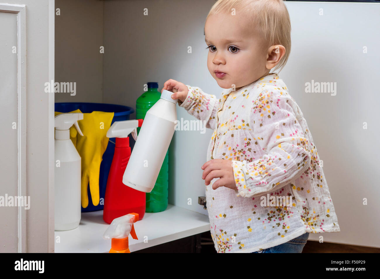 Bambino gioca con detergenti a casa Foto Stock