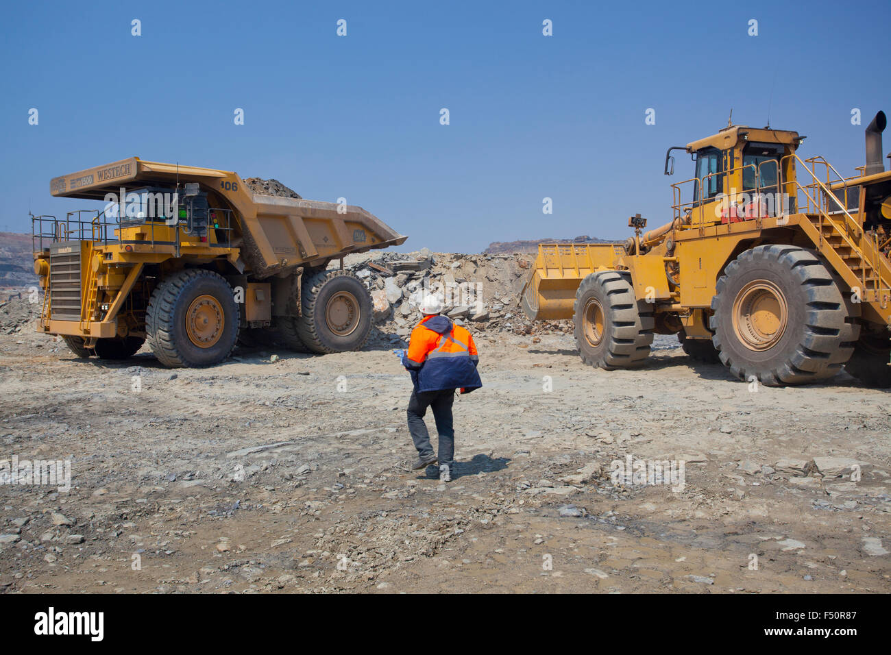 Caricatore a estremità anteriore e grandi haul dump il mio carrello con terreno scavato. Settore minerario in Zambia, Africa. Foto Stock