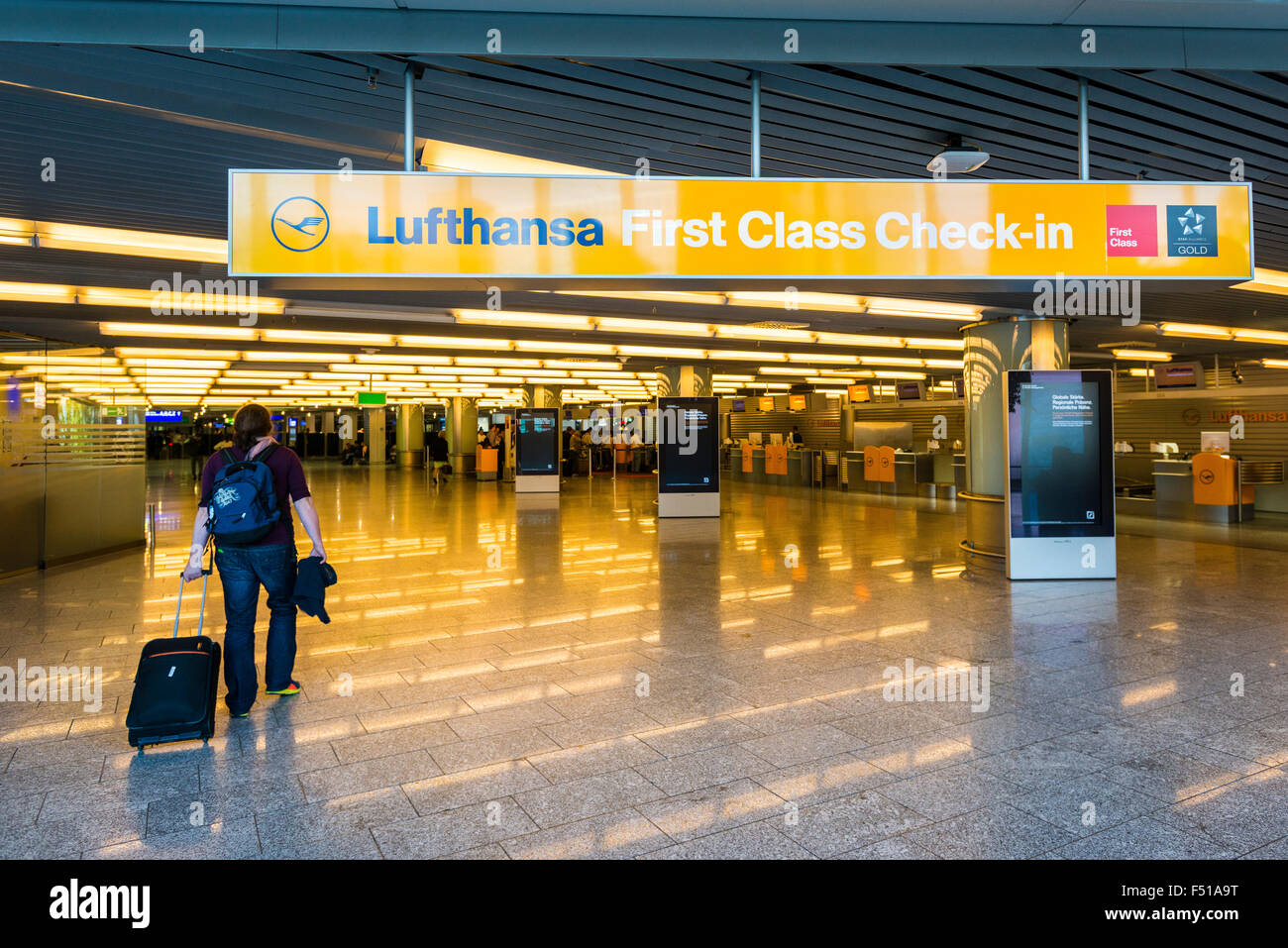 Una donna con la valigia è a piedi in prima classe check-in della compagnia  Lufthansa al terminale 1 di Frankfurt international Foto stock - Alamy