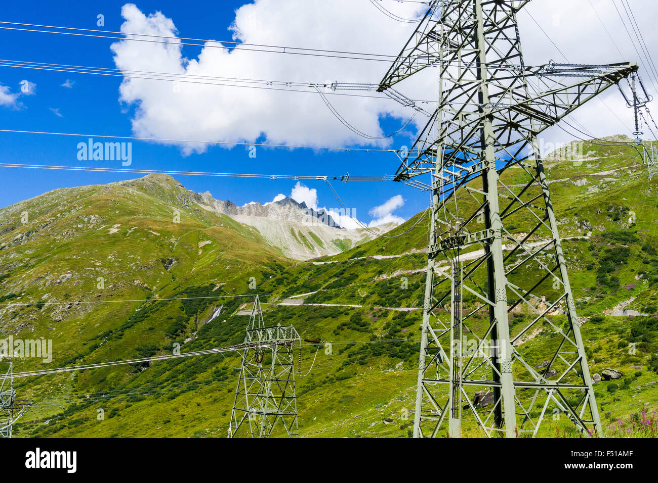 Una linea elettrica attraversa le montagne verdi pendii in alta quota Foto Stock