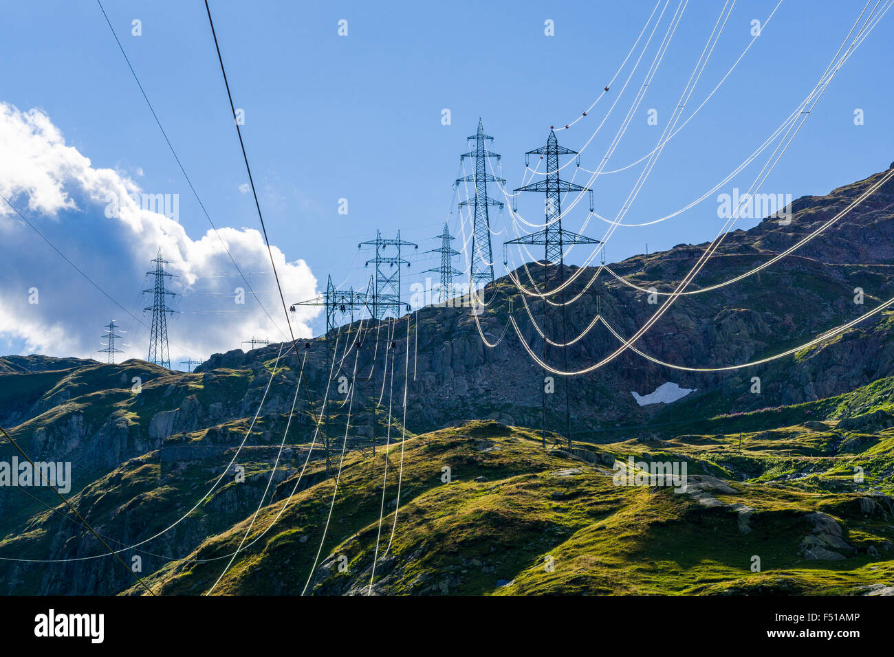 Una linea elettrica attraversa le montagne verdi pendii in alta altitudine vicino nufenenpass Foto Stock