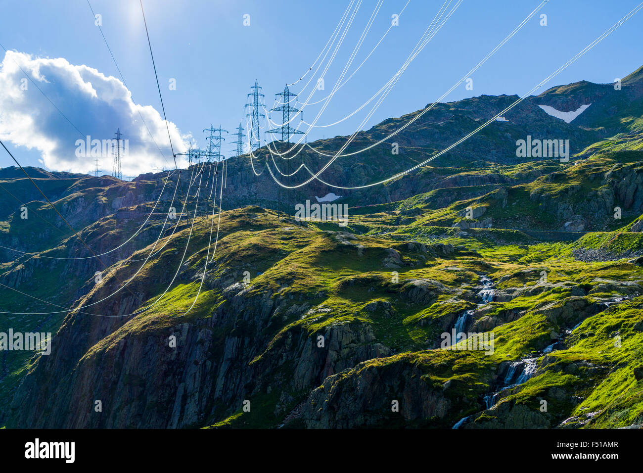 Una linea elettrica attraversa le montagne verdi pendii in alta altitudine vicino nufenenpass Foto Stock